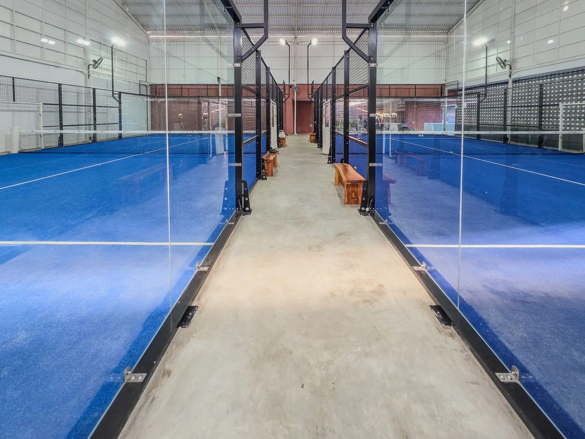 Club de pádel indoor con canchas de césped azul